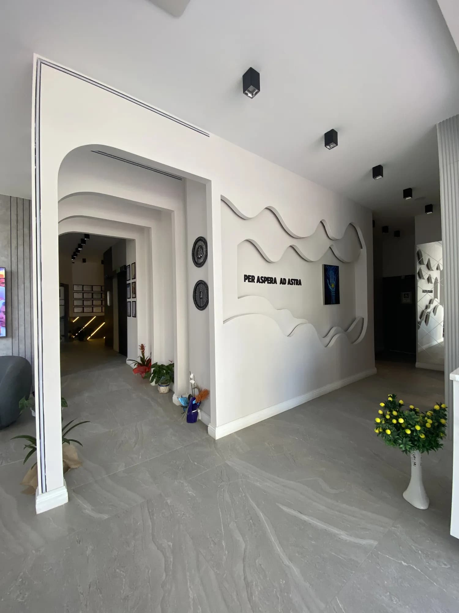 AC CLINIC koridoru ve 'Per Aspera Ad Astra' duvar yazısı